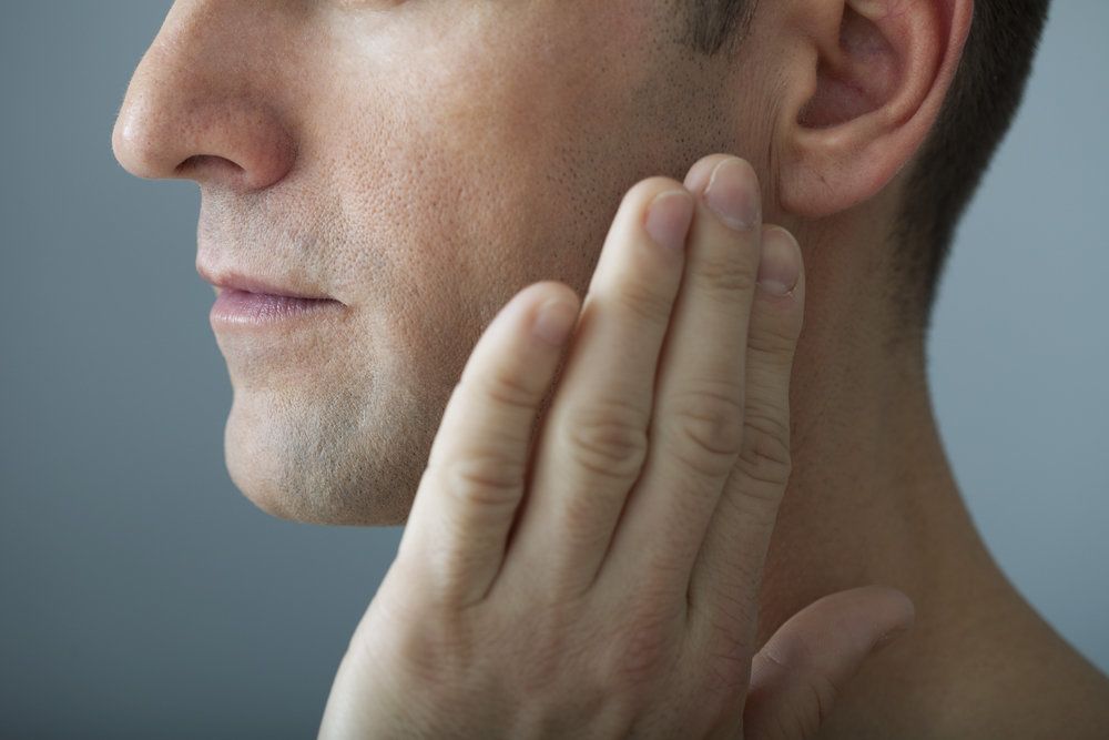 Man rubbing jaw