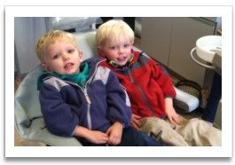Two young blond boys in dental exam chair